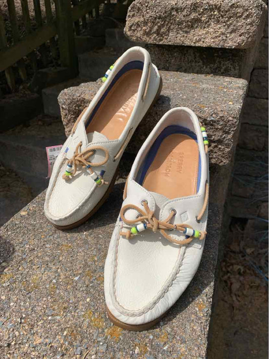 Women’s white leather Sperry boat shoes with tan laces and beaded accents, size 9.5.
