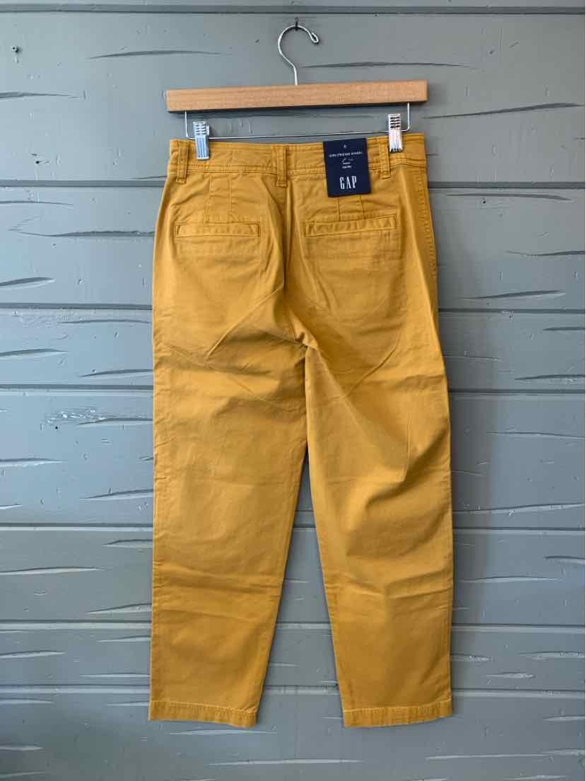 Mustard yellow GAP pants with a straight-leg cut, front pockets, and a navy logo patch at the waistband.