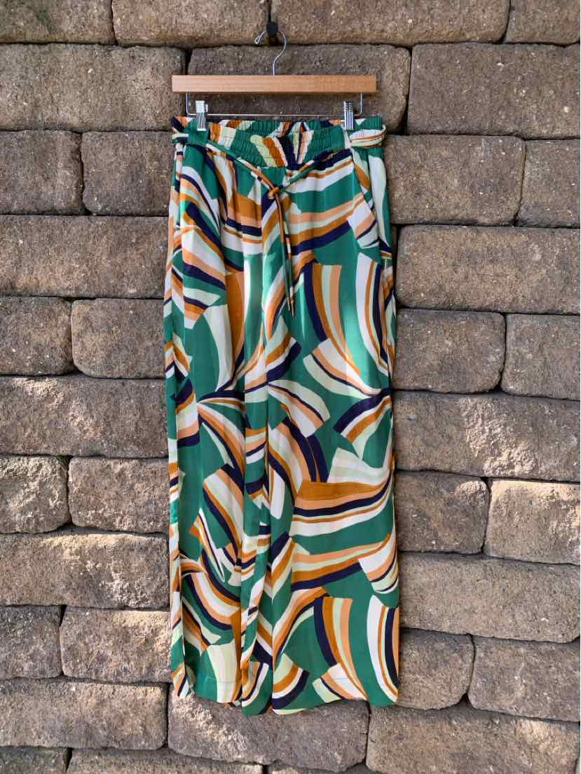 High-waisted wide-leg pants with abstract green, white, mustard, and navy swirl pattern.