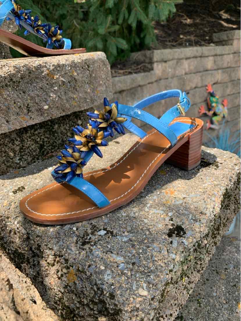Blue leather open-toe sandal with block heel and gold-tone floral embellishments across the strap.