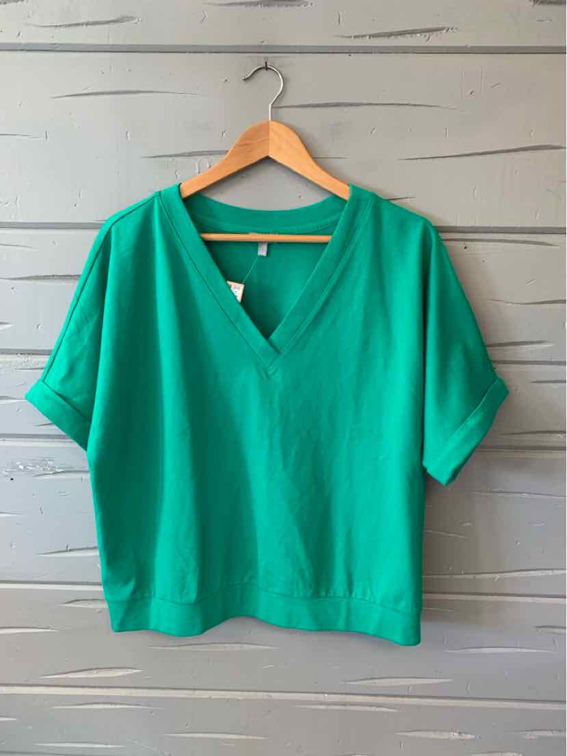 Green short-sleeve blouse with V-neck and relaxed fit on wooden hanger.
