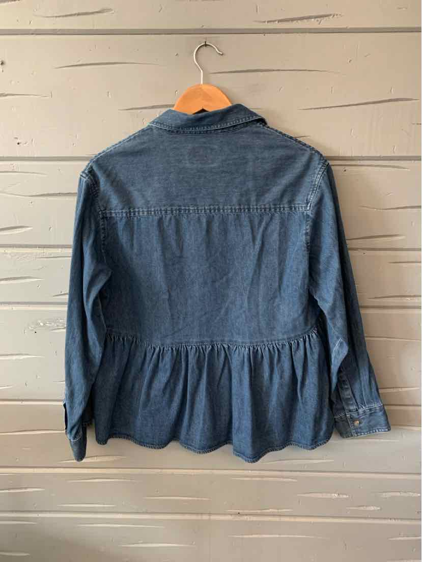 Blue denim long-sleeve blouse with gathered peplum waist and buttoned cuffs hanging on wooden hanger.