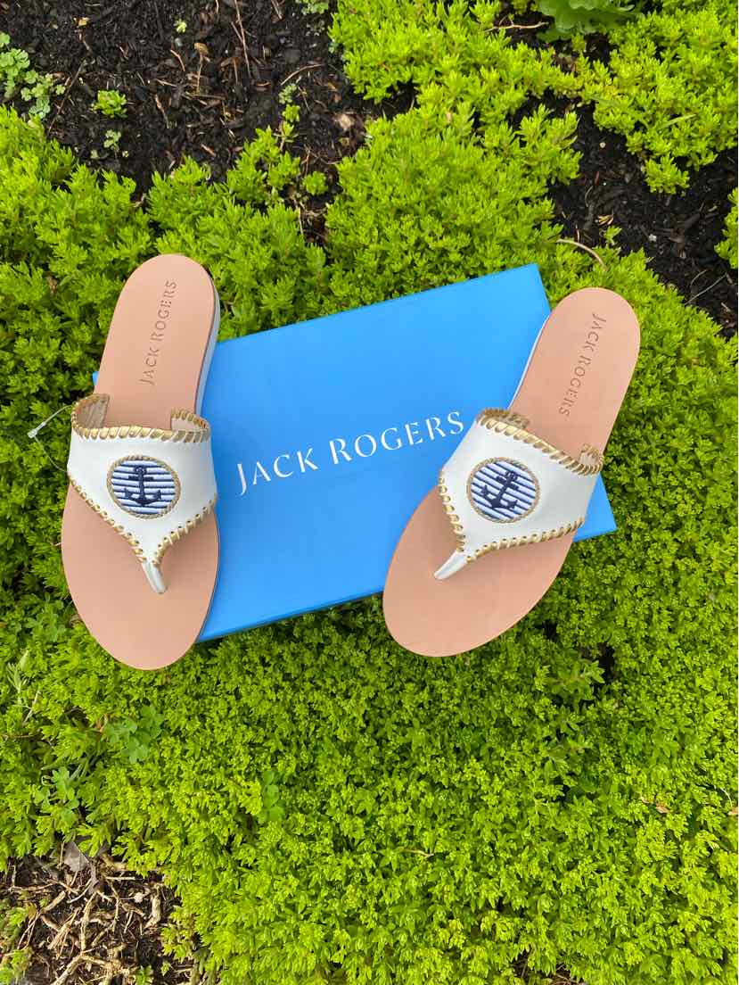 White leather Jack Rogers sandals with anchor emblem and braided trim, size 8, displayed on blue box outdoors.
