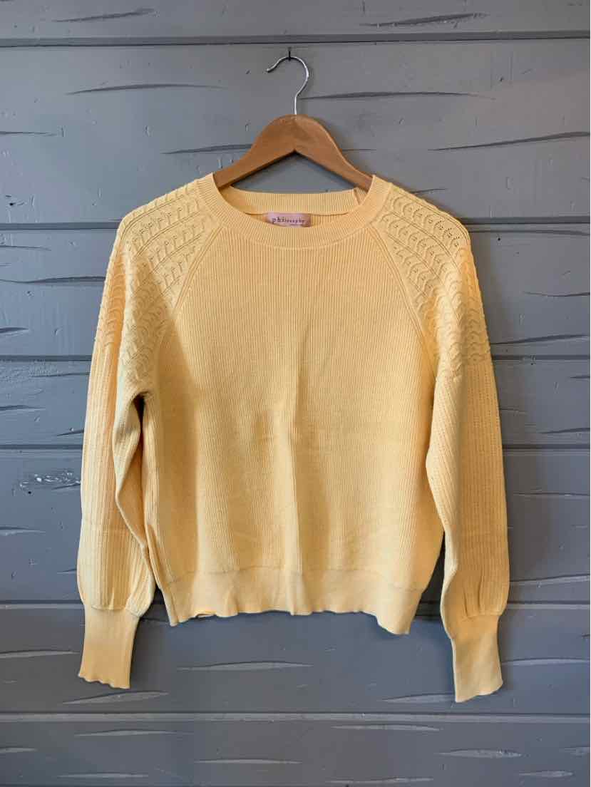 Light yellow knit sweater with textured shoulder panels and ribbed cuffs and hem.