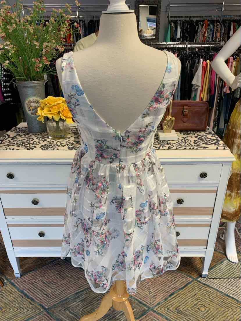 White floral sleeveless dress with deep V-back and cinched waist, size 6.