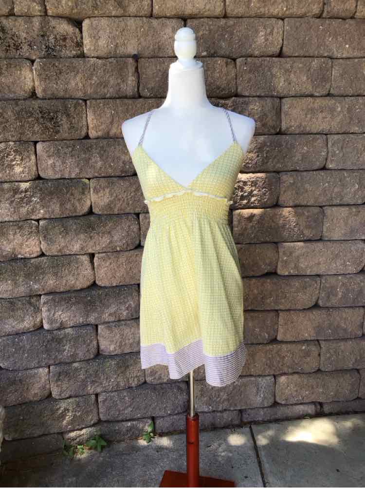 Yellow sleeveless summer dress with thin straps, V-neckline, and white lace hem detailing.