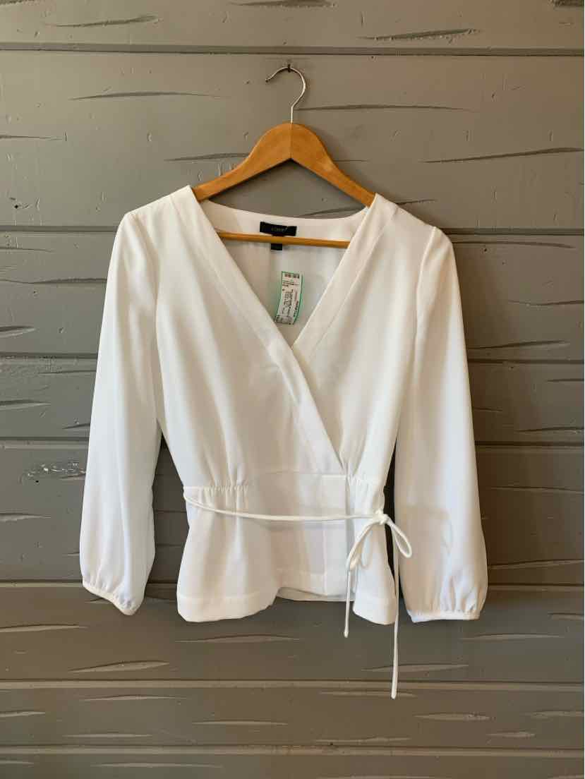 White long-sleeve wrap top with V-neck and side tie detail on wooden hanger.