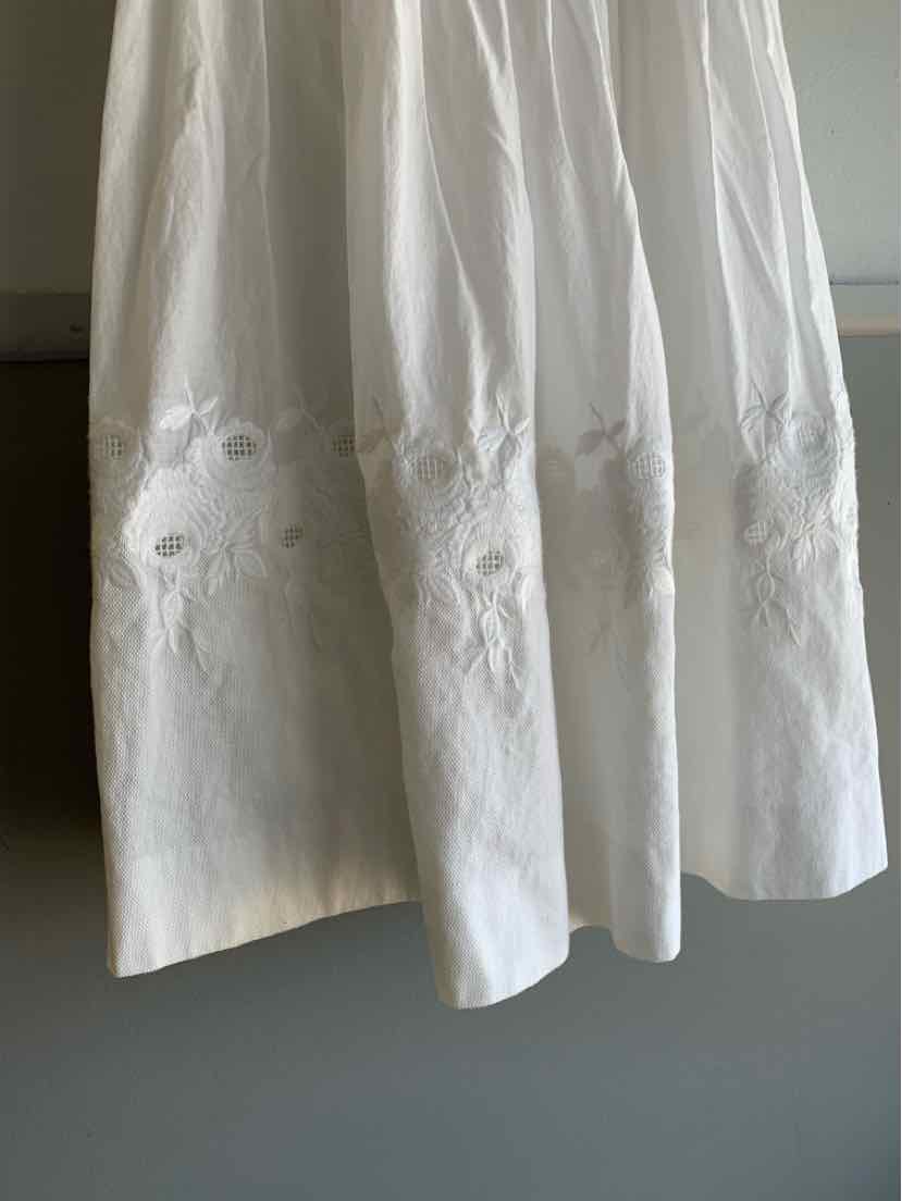 White cotton dress with floral embroidery near the hem, size 0, flowy style.
