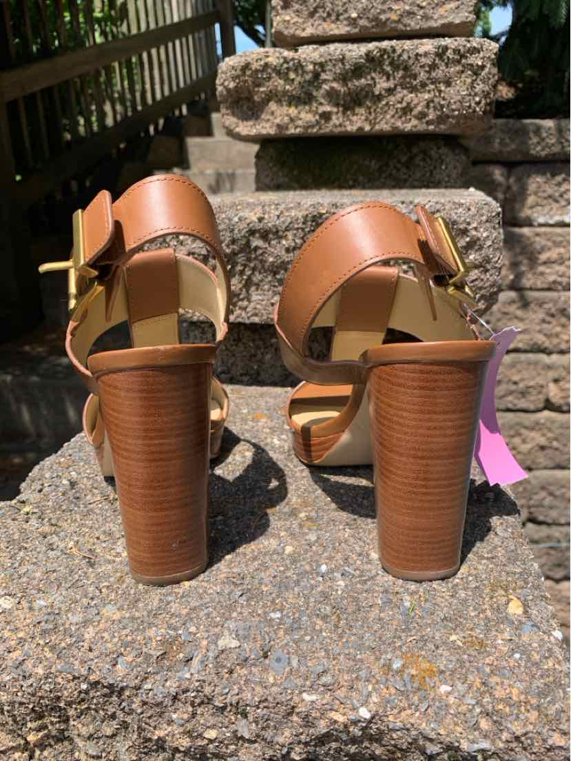 Tan leather high-heeled sandals with wide ankle straps and gold buckle details, size 6.