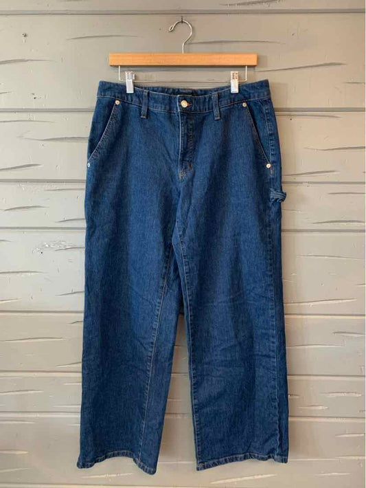High-waisted straight-leg dark blue denim jeans with front pockets and belt loops hanging on wooden hanger.
