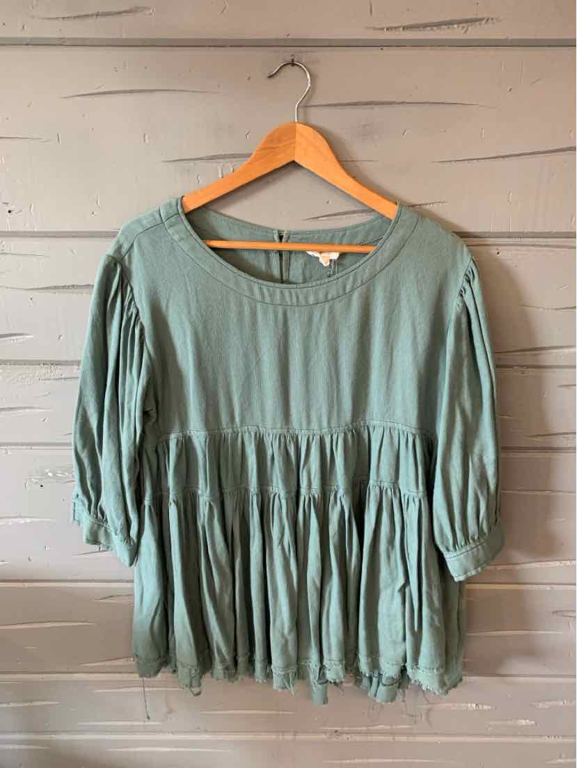 Light sage green loose blouse with three-quarter puff sleeves and gathered waist detailing.