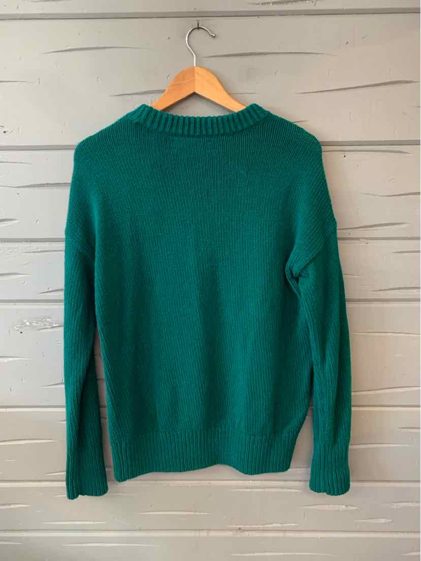 Green knitted long-sleeve sweater with ribbed collar, cuffs, and hem hanging on wooden hanger.