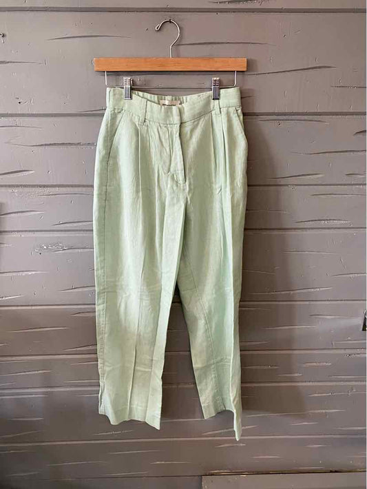 Light green high-waisted Abercrombie and Fitch pants in size XS hanging on wooden hanger.