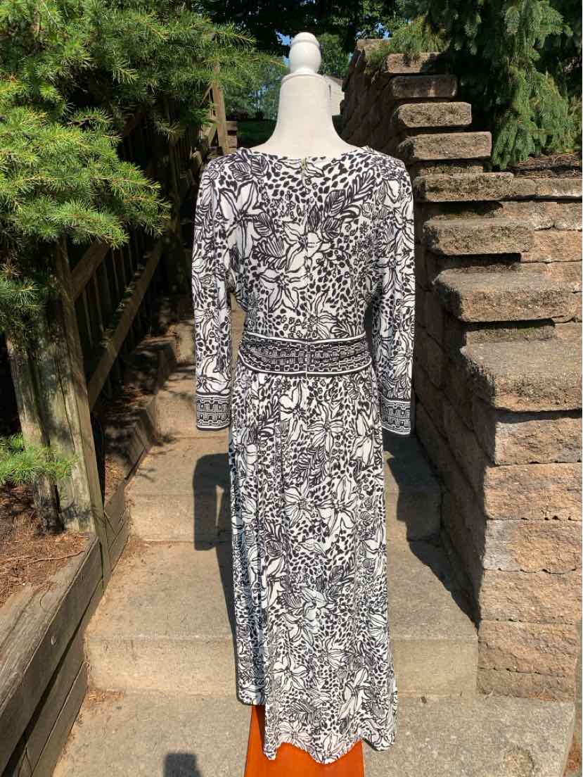 Black and white floral midi dress with long sleeves and cinched waist detail.
