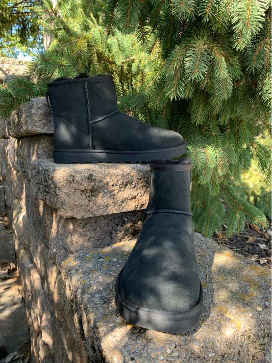 Pair of black leather UGG ankle boots with rounded toes, thick soles, and side zipper closures.