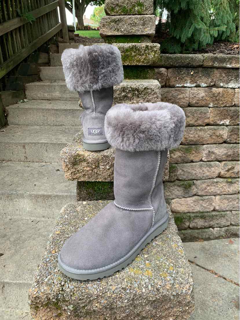 Gray suede mid-calf UGG boots with plush fur cuff and rubber sole, women's size 8.
