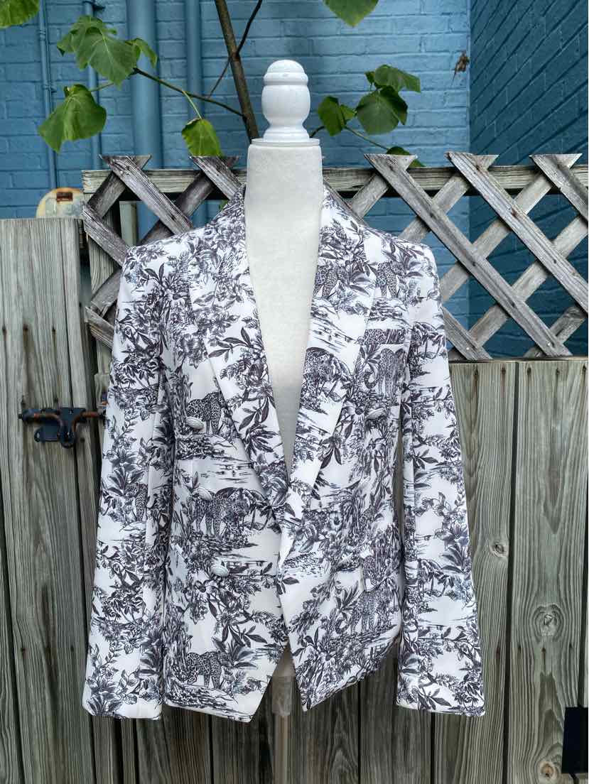 White blazer with black floral print, tailored fit, and notch lapels on mannequin.