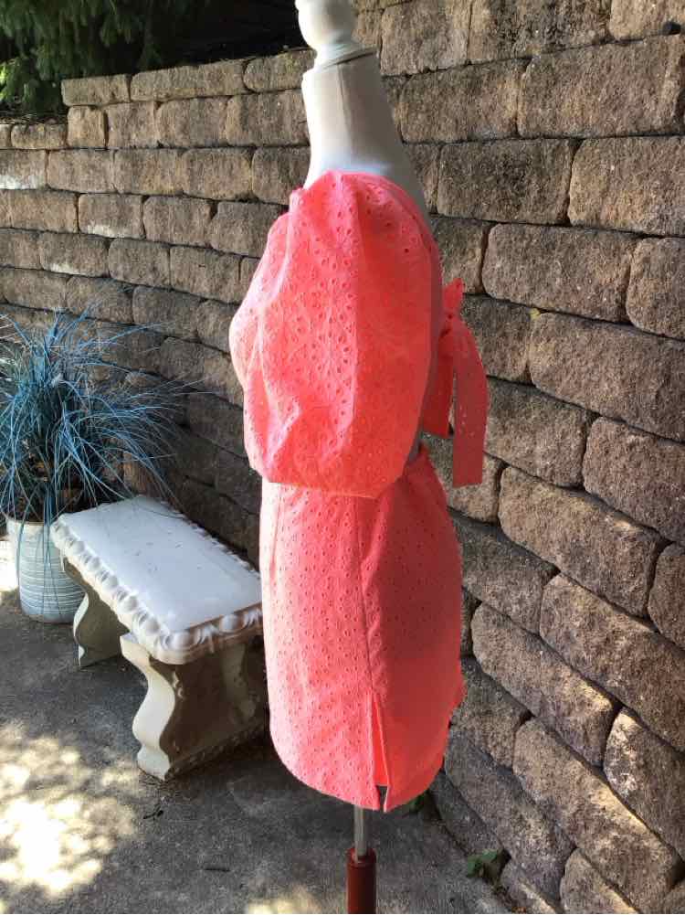 Coral pink eyelet dress with puff sleeves and cinched waist tied in back, size 0.