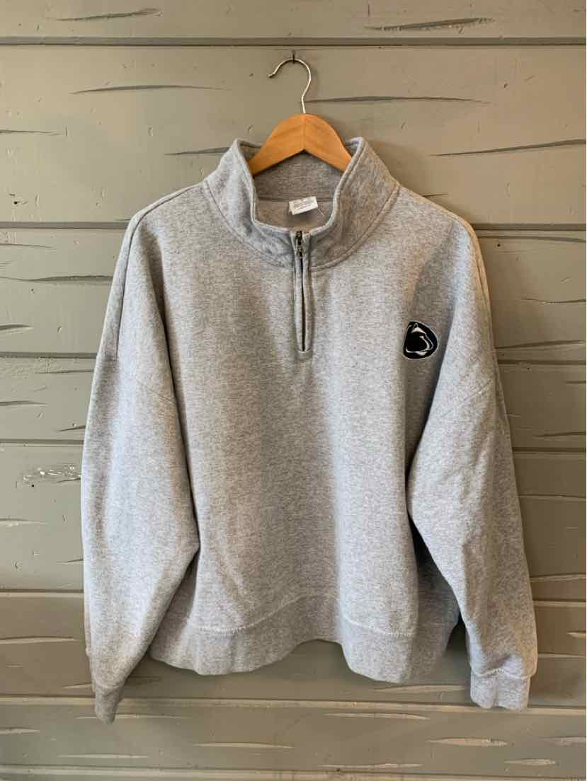 Gray quarter-zip sweatshirt with stand collar, long sleeves, and small black and white logo patch on chest.