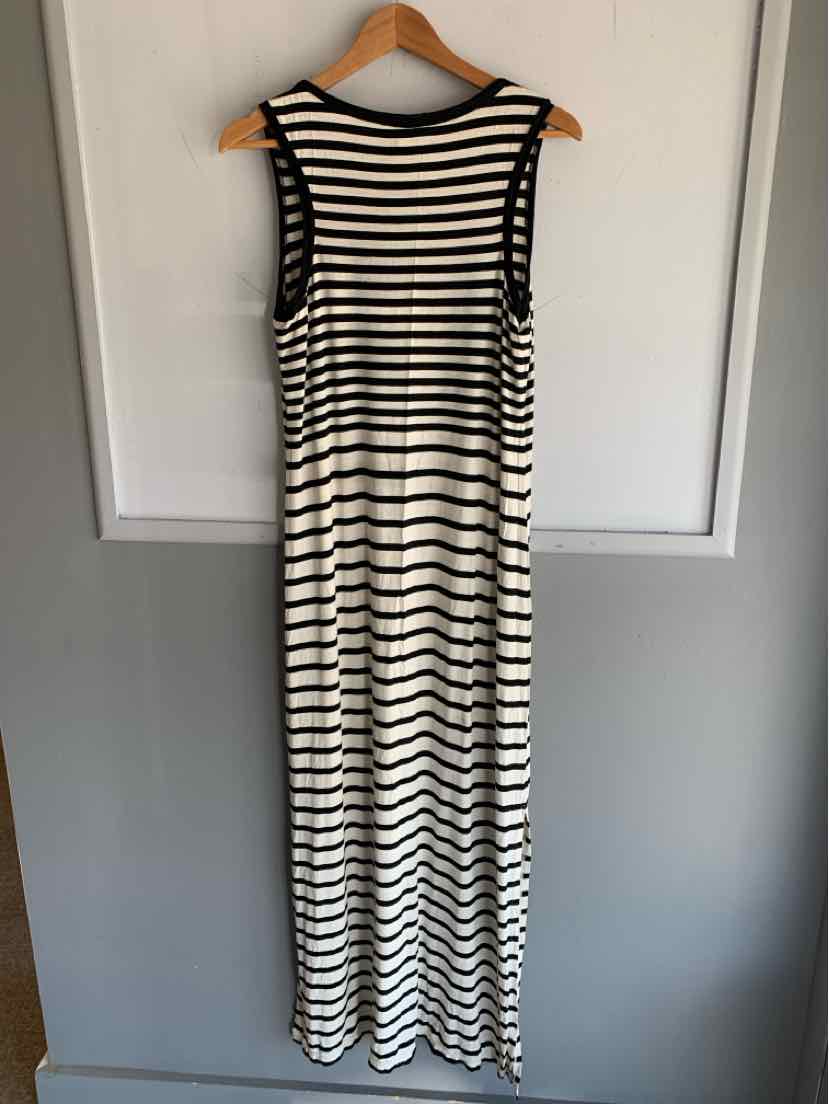 Sleeveless long black and white horizontal striped dress with round neckline hanging on wooden hanger.