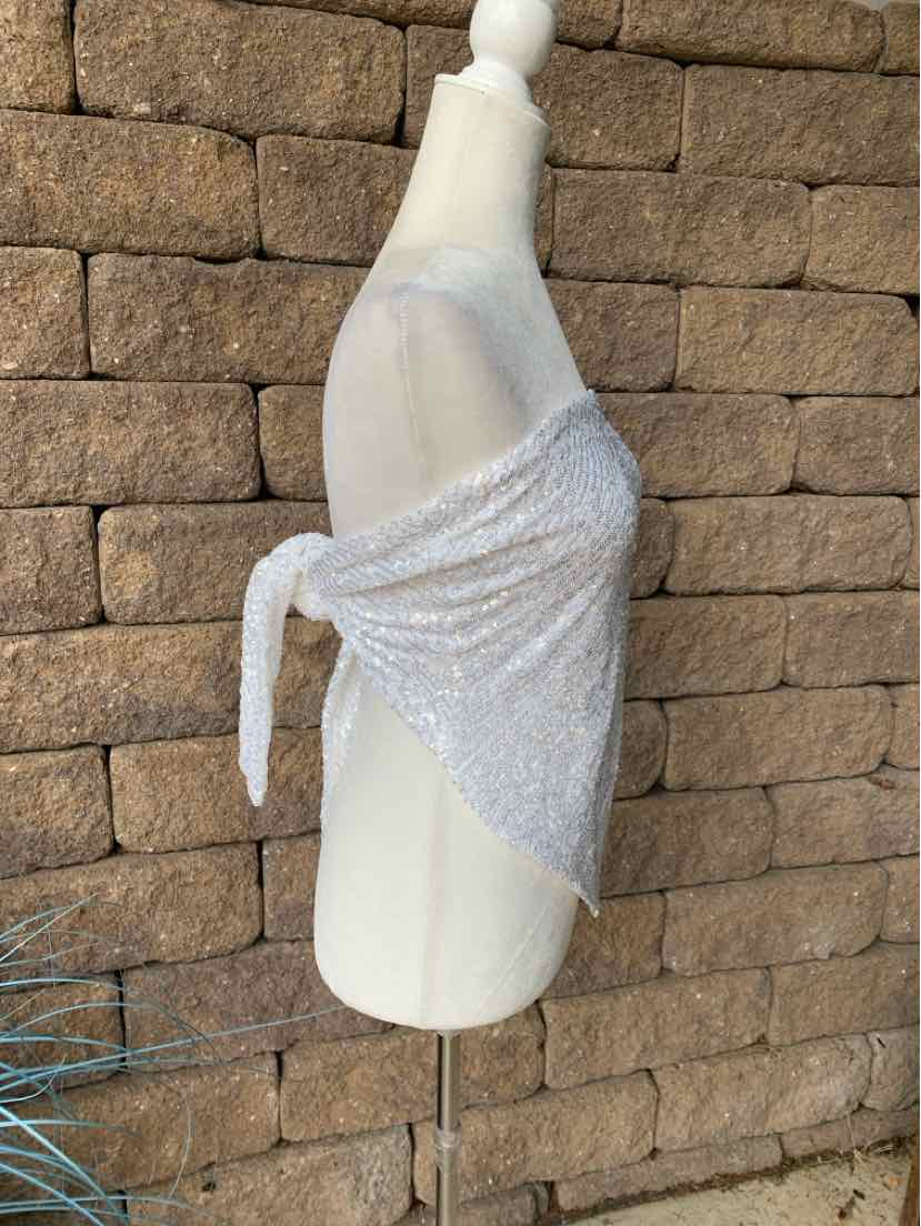 White sequin wrap top with a tie closure, draped asymmetrically on a mannequin.