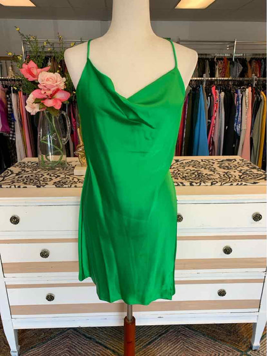 Green satin slip dress with cowl neckline and thin spaghetti straps on mannequin.