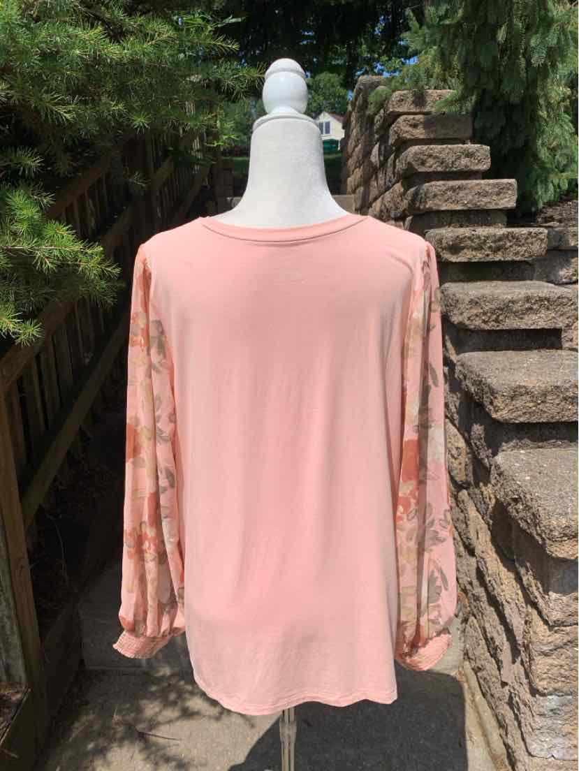 Light pink long-sleeve blouse with floral patterned sheer sleeves and round neckline.