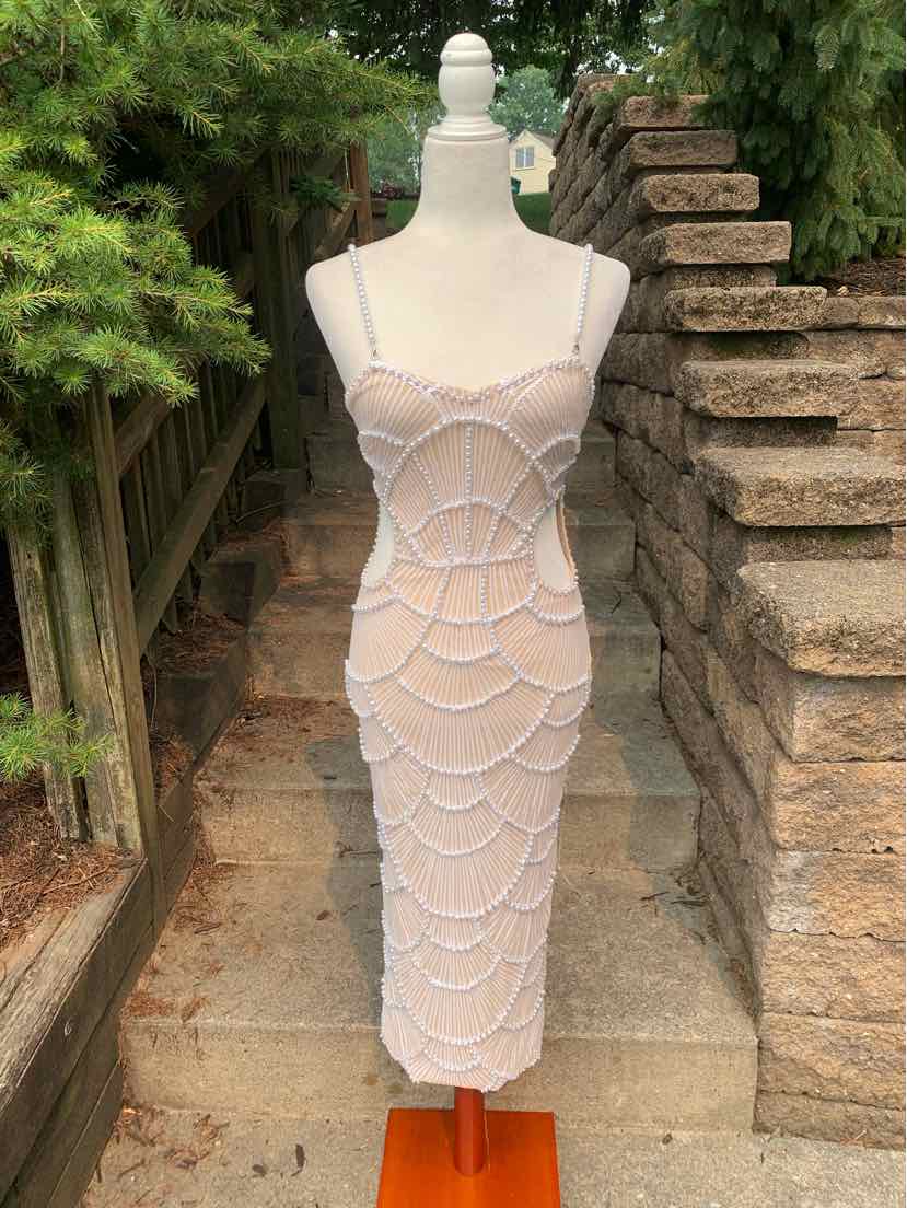 Tan midi dress with scalloped layered design, thin spaghetti straps, and fitted silhouette.