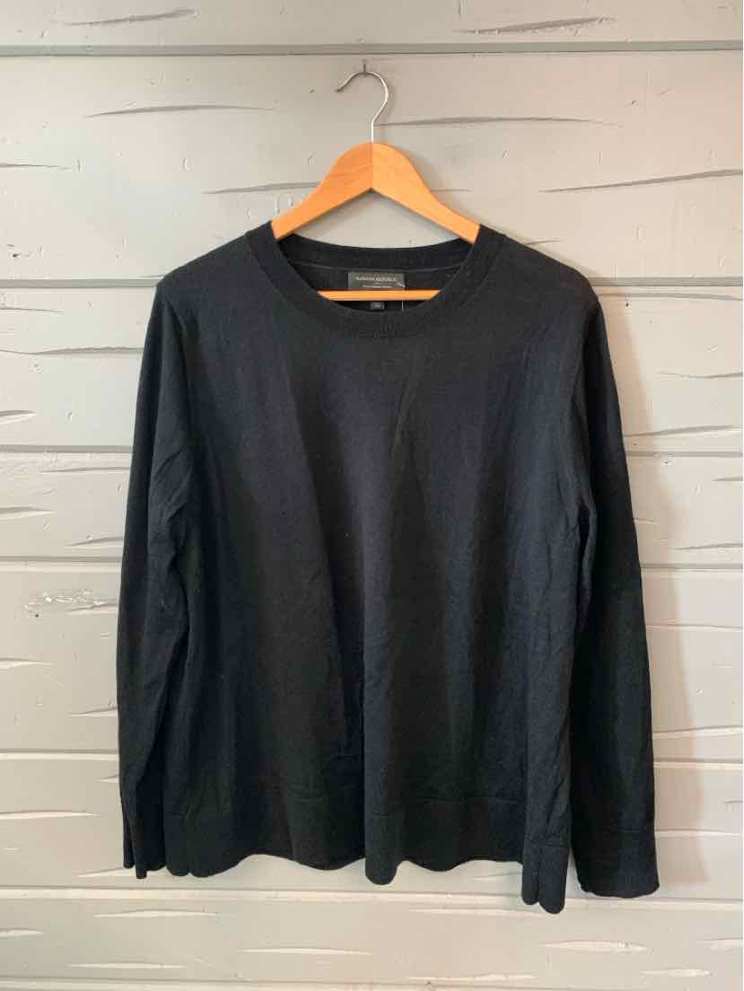 Black long-sleeve crewneck shirt in size XL with a smooth cotton fabric hanging on a wooden hanger.
