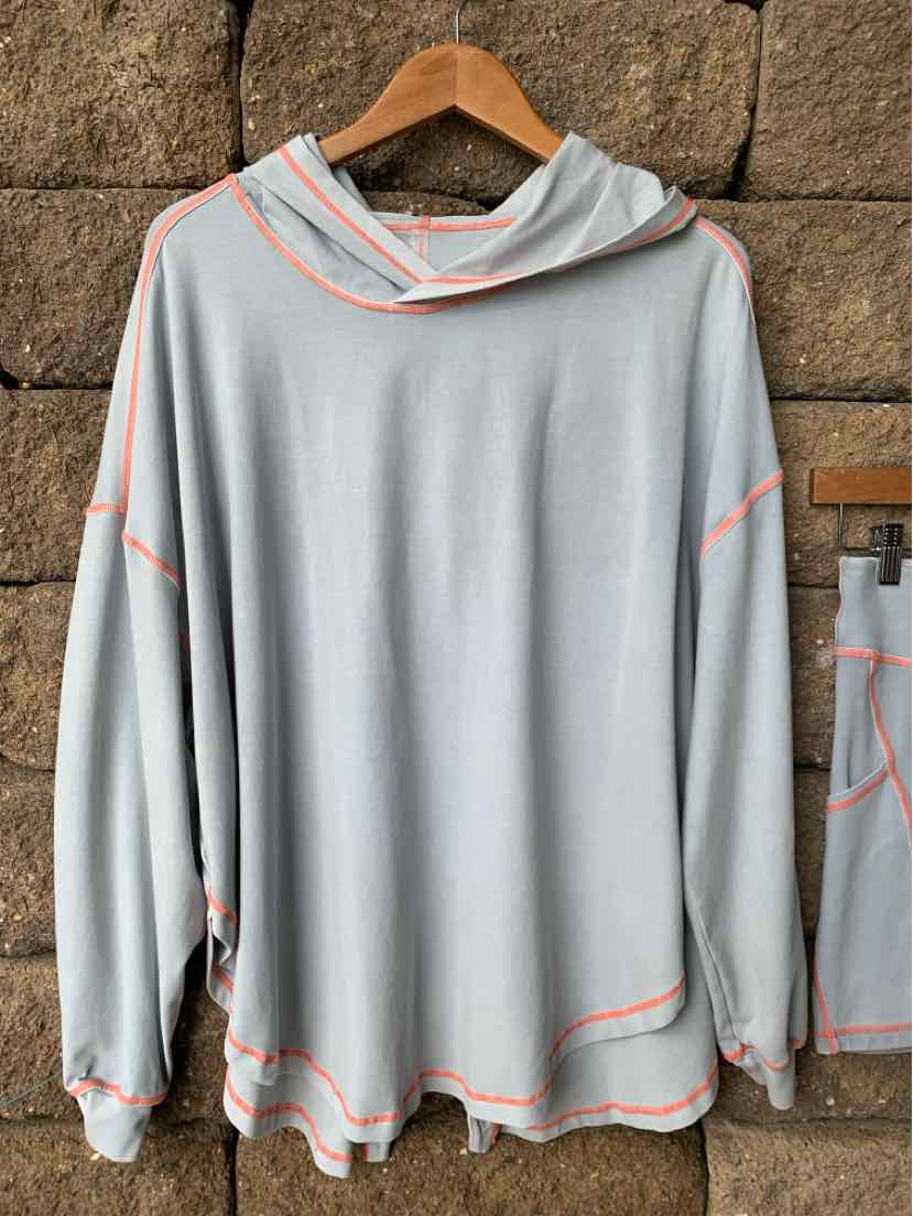 Light blue long-sleeve hooded sweatshirt with relaxed fit and orange contrast stitching.
