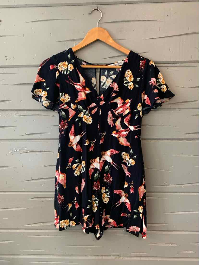 Black short-sleeve romper with colorful bird print and front tie detail.