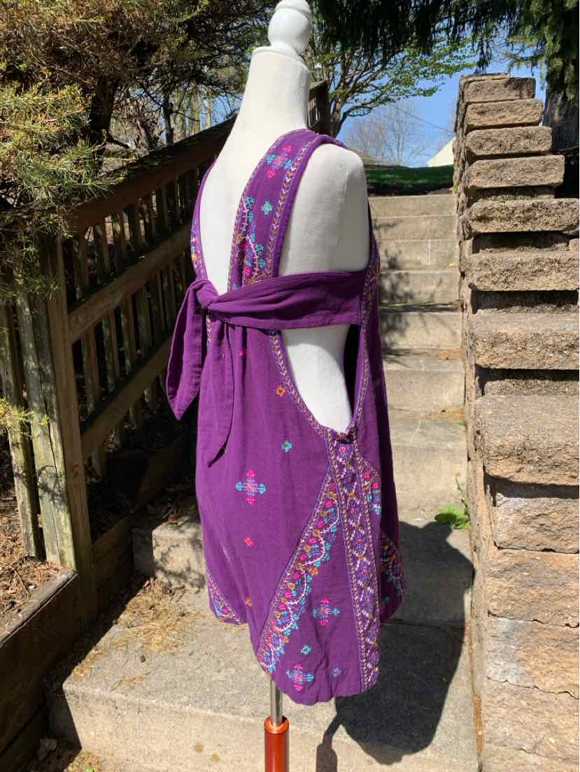 Purple sleeveless dress with floral embroidery and deep V back tied at waist, lightweight fabric.