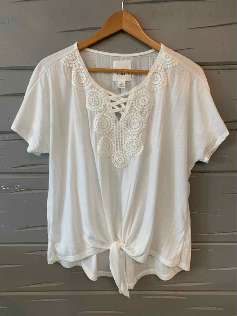 White short-sleeve blouse with lace V-neck detail and front tie hem on wooden hanger.