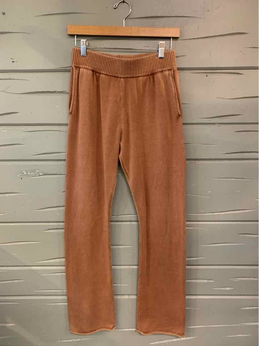 Tan-colored straight-leg pants in a soft knit fabric with an elastic waistband and side pockets.