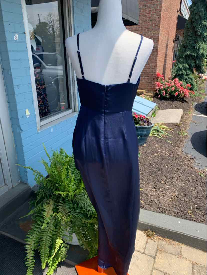 Navy blue satin midi dress with thin adjustable straps and fitted silhouette displayed on mannequin outdoors.