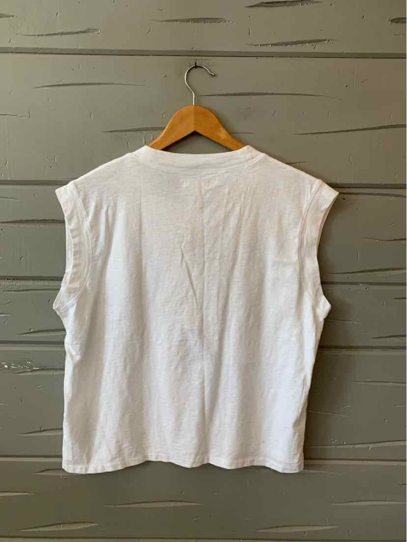 White sleeveless cotton t-shirt with a crew neckline and relaxed fit hanging on wooden hanger.