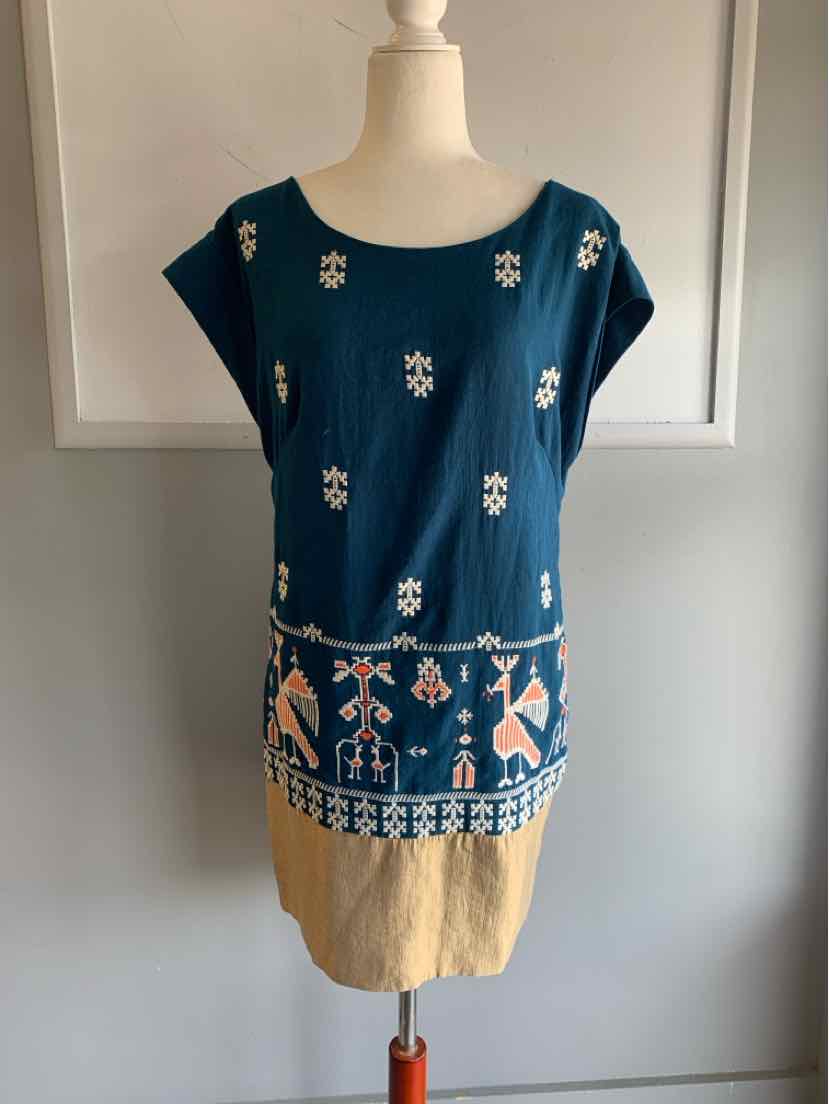 Blue sleeveless blouse with tribal white and beige embroidery and a scoop neckline.