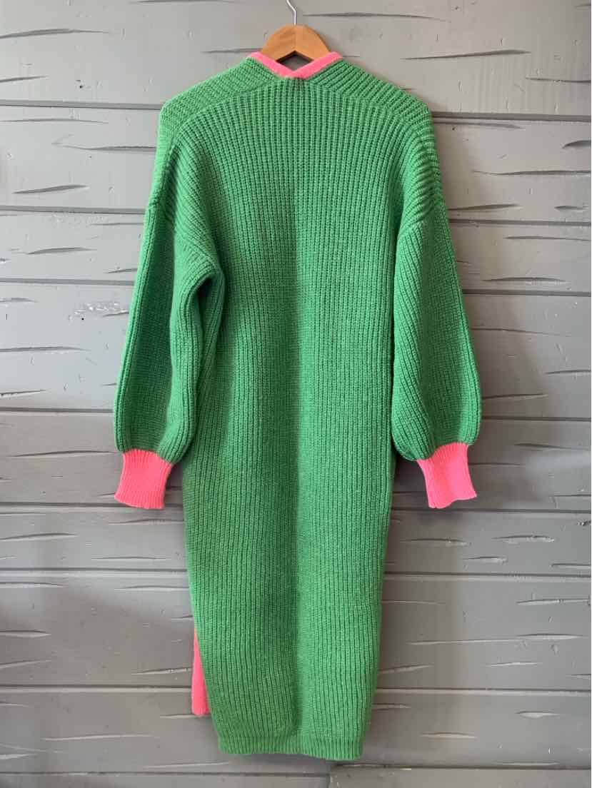 Long green knit sweater dress with ribbed texture, featuring bright pink cuffs and a pink collar.