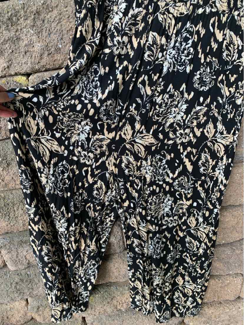 Black sleeveless jumpsuit with beige floral pattern and loose, flowy fabric in size XXL.