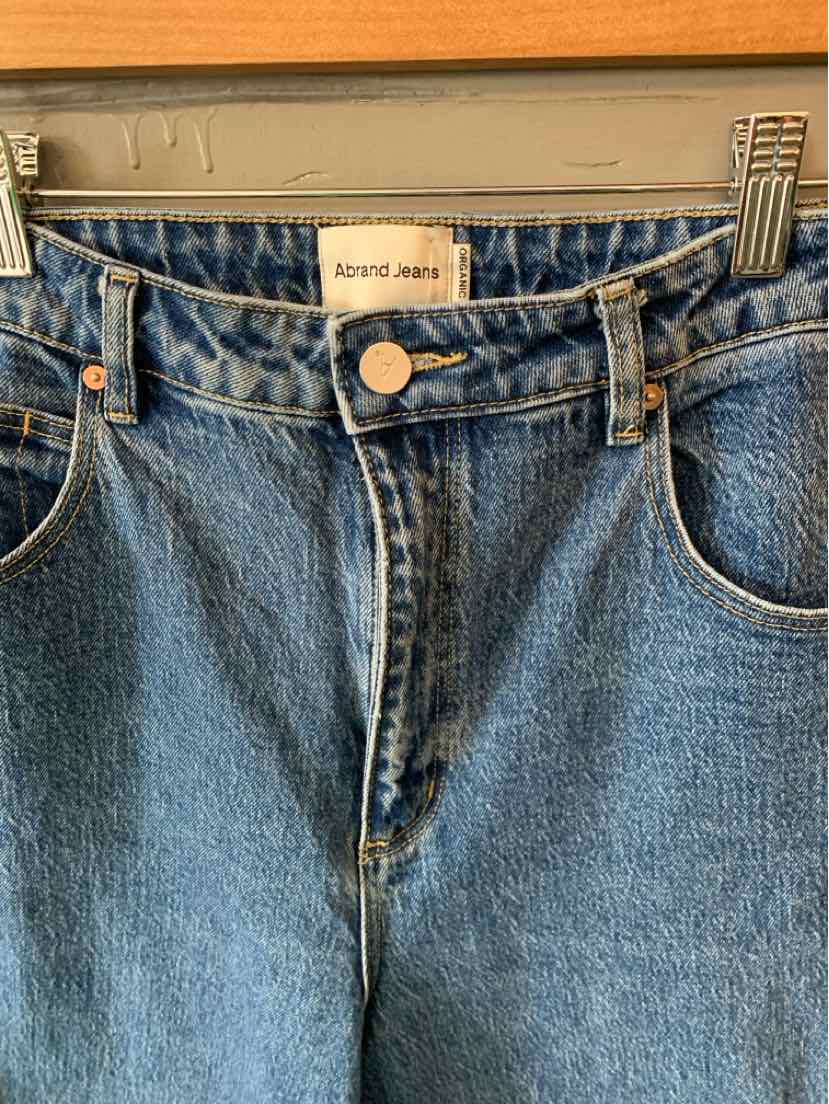 High-waisted blue denim jeans with front button closure and belt loops.