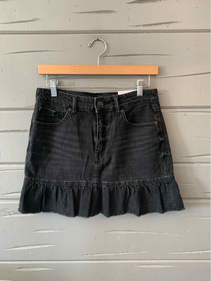 Black denim mini skirt with front pockets and ruffled hem, size 6.