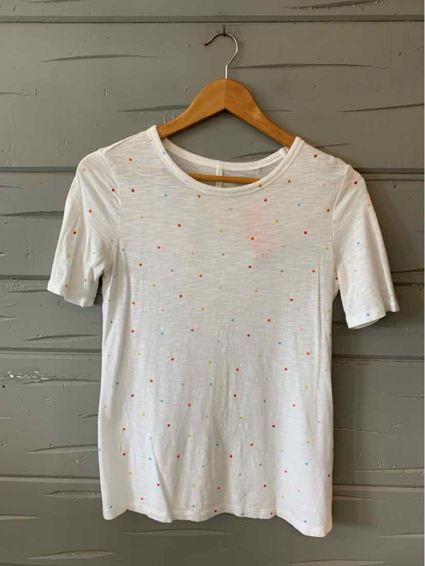 White short-sleeve fitted top with small multicolored polka dots and round neckline.