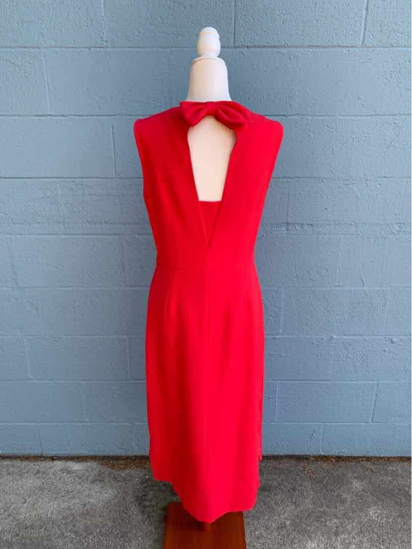 Red sleeveless midi dress with keyhole neckline and bow detail at collar on mannequin.