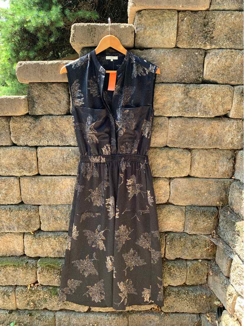 Black sleeveless midi dress with subtle floral print and V-neckline on wooden hanger.