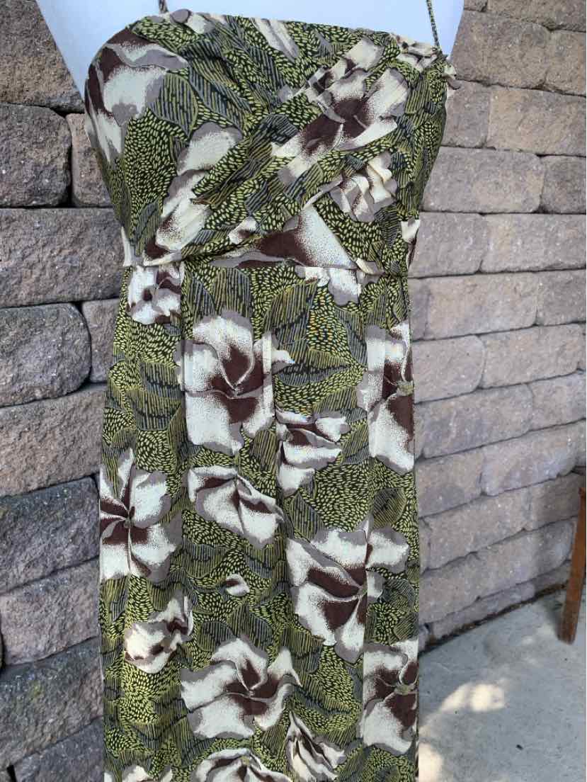Green floral sleeveless dress with fitted bodice and long flowing skirt.