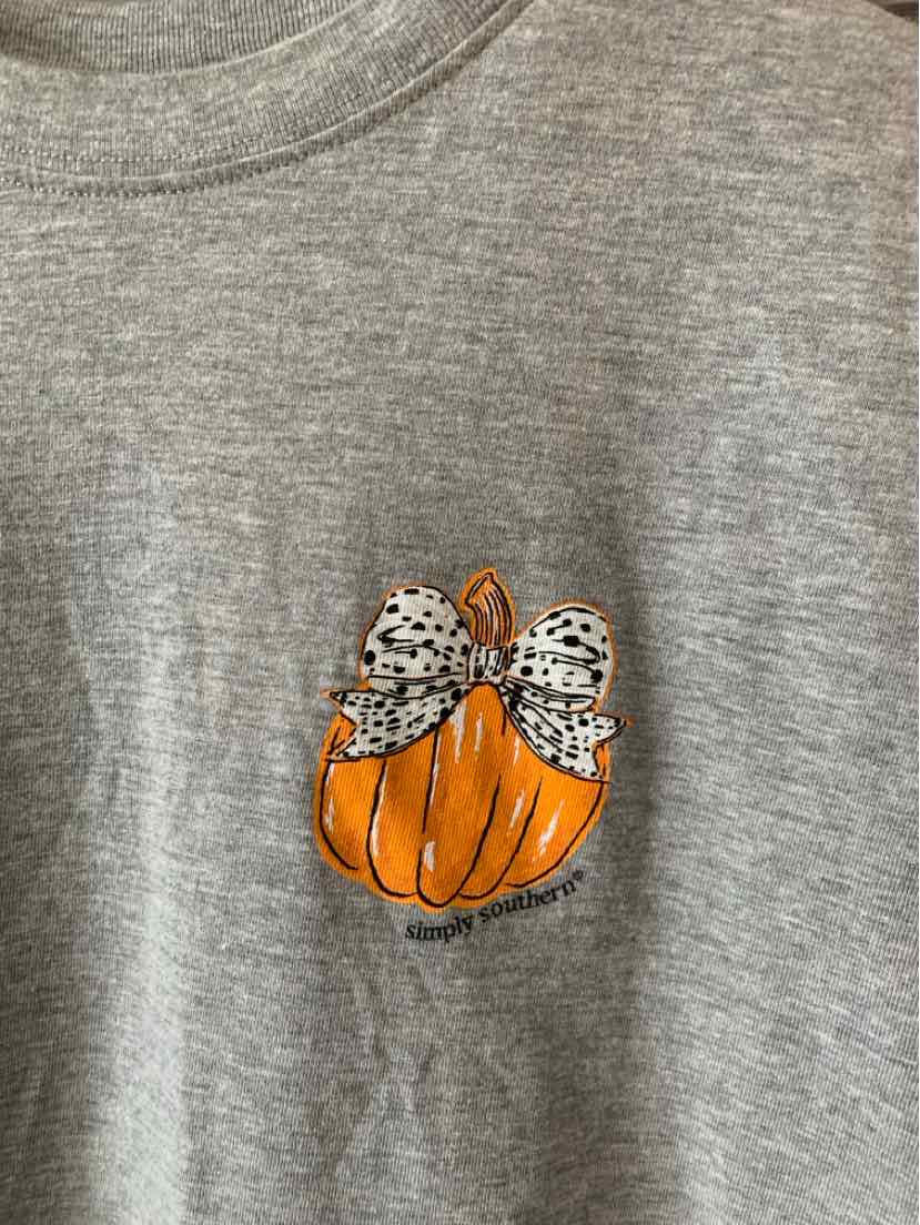 Gray t-shirt with small orange pumpkin graphic wearing a white polka dot bow on the chest.