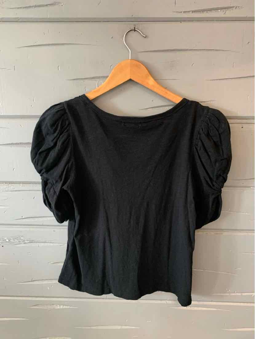 Black short-sleeve top with puffed sleeves and a round neckline on a wooden hanger.