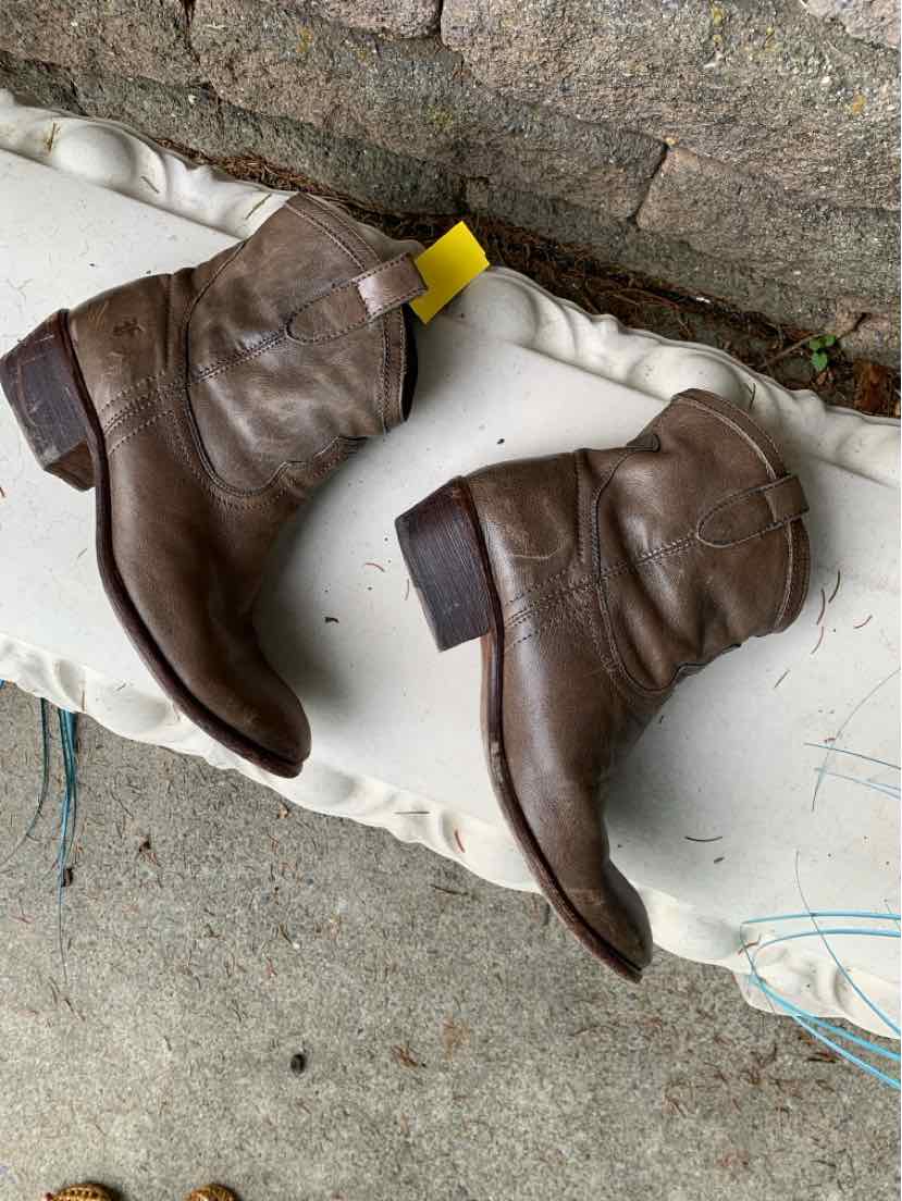 Brown leather ankle boots with a low stacked heel and round toes, featuring a yellow pull tab.
