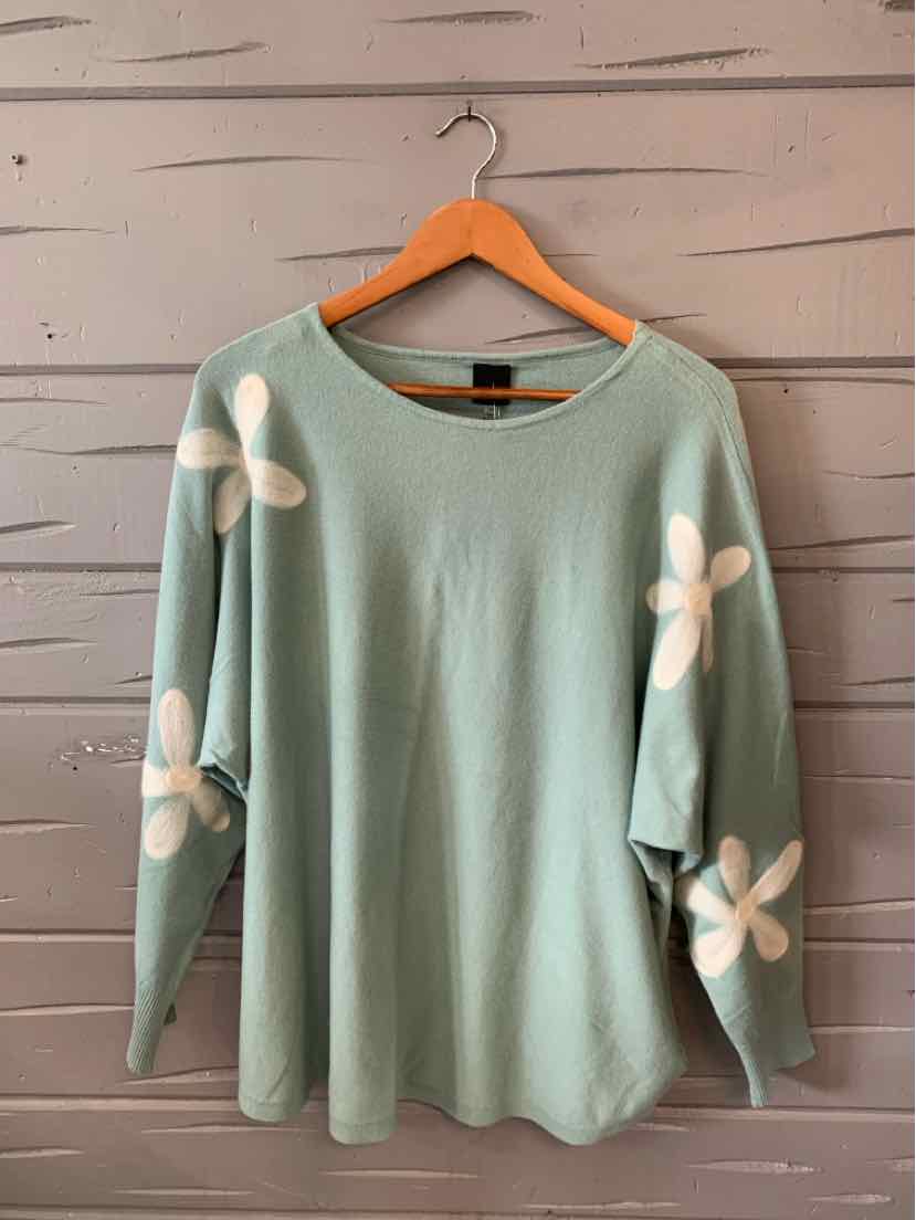 Light green long-sleeve sweater with large white flower patterns on sleeves, crew neckline, relaxed fit.
