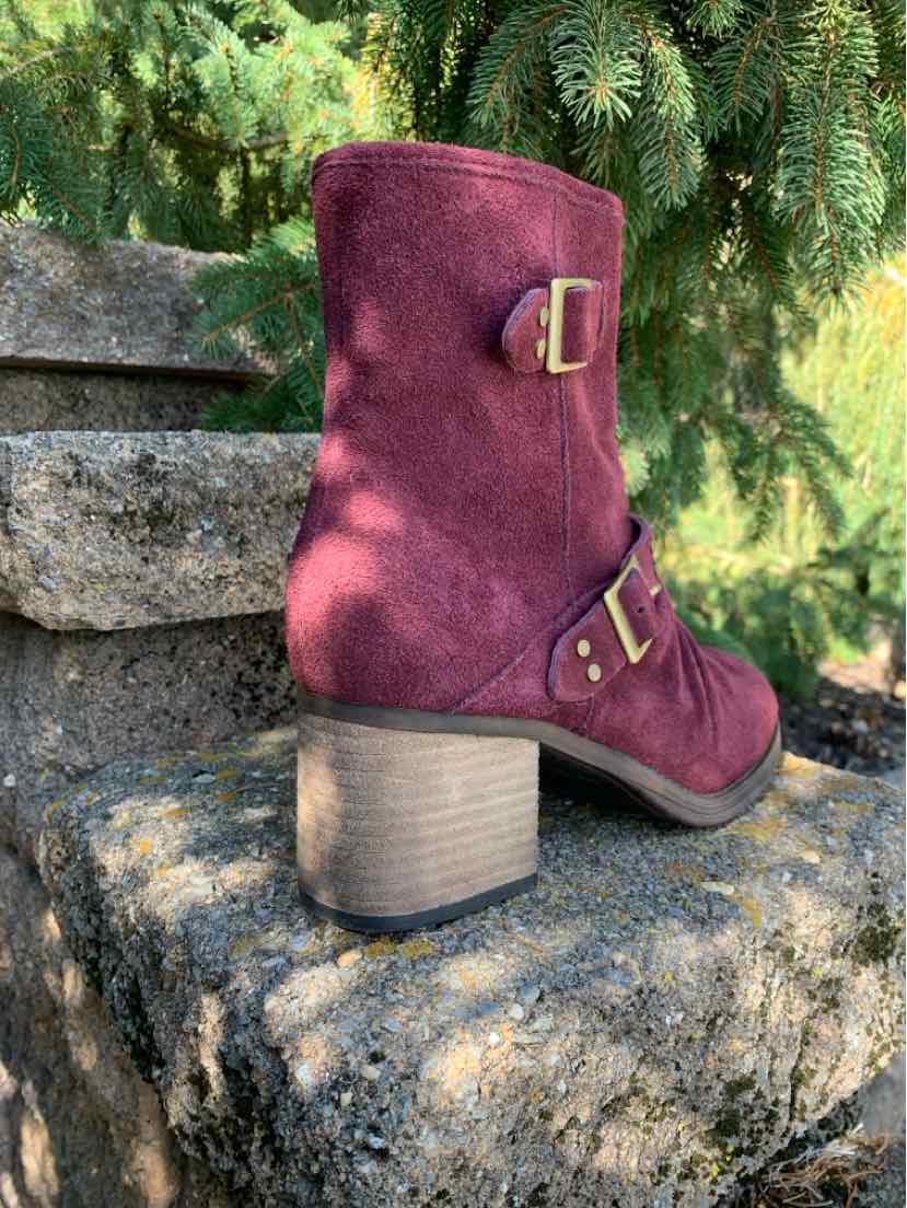 Burgundy suede mid-calf boots with gold-tone buckles and stacked beige heels.